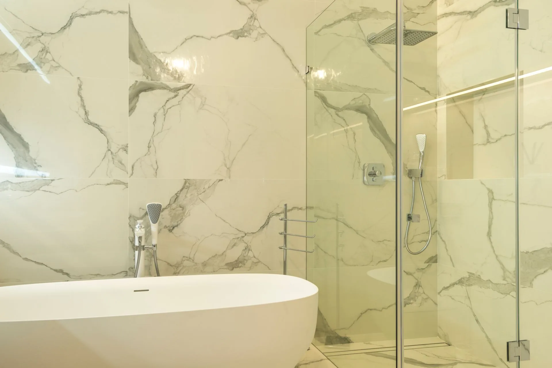 Luxury marble bathroom with modern bathtub and glass shower enclosure