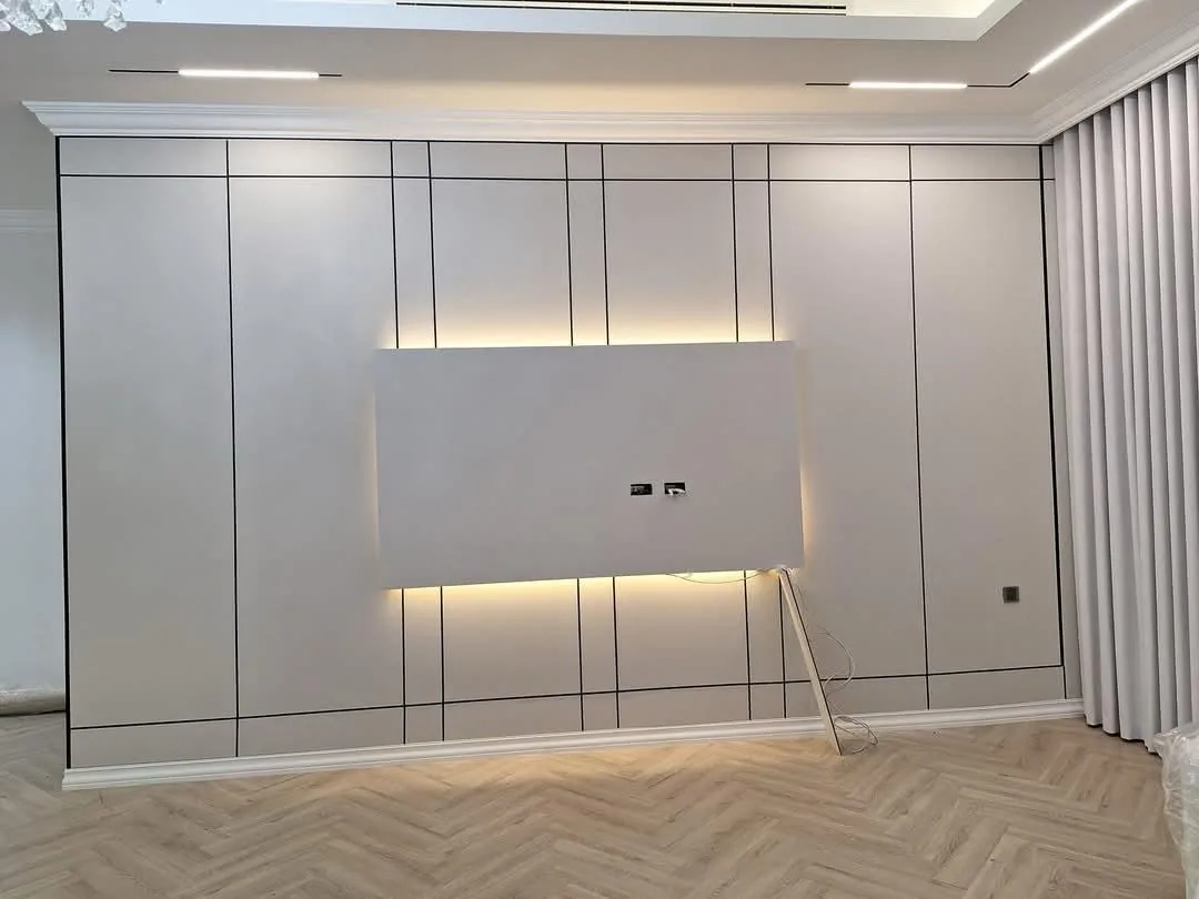Grid-panelled wall with a backlit TV backdrop above herringbone flooring