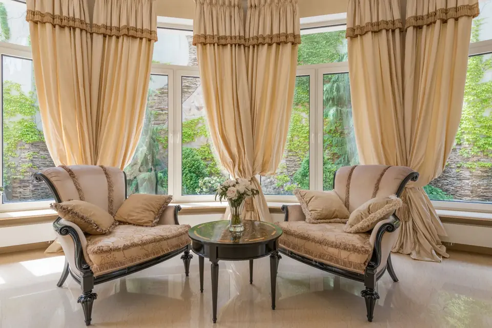 Elegant beige floor-to-ceiling curtain drapery in a luxury living room