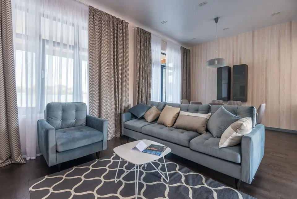 Modern patterned curtains in an elegant living room with sofa and armchair