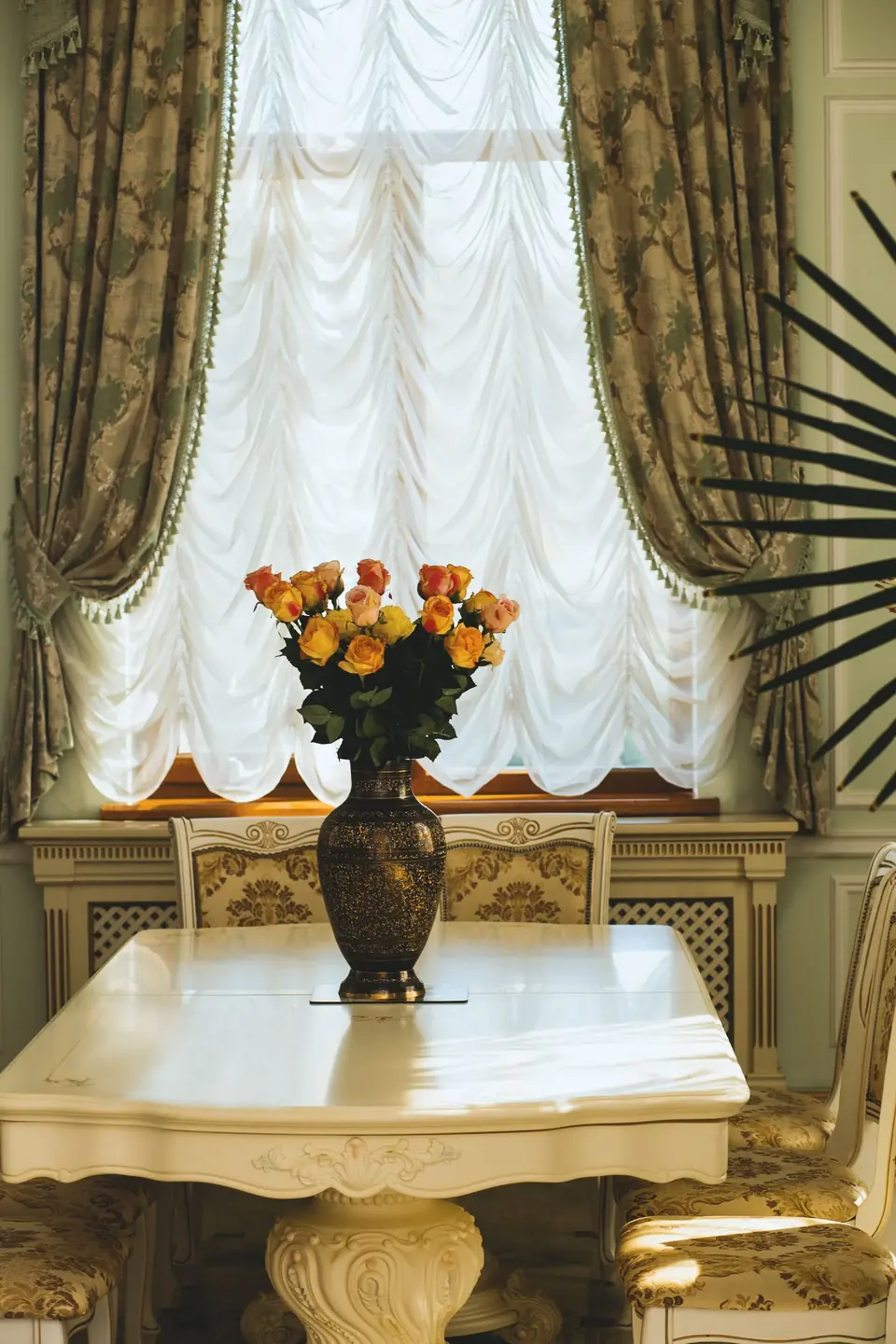 Ornate curtain beside a window in a luxurious dining room