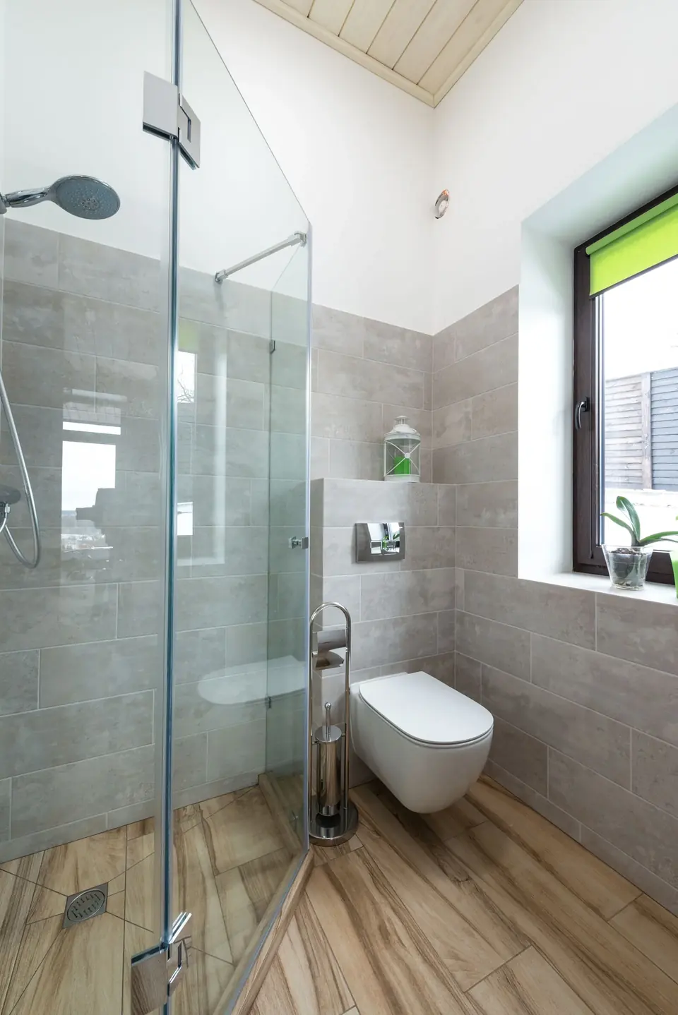 Contemporary glass shower design with wooden bathroom flooring