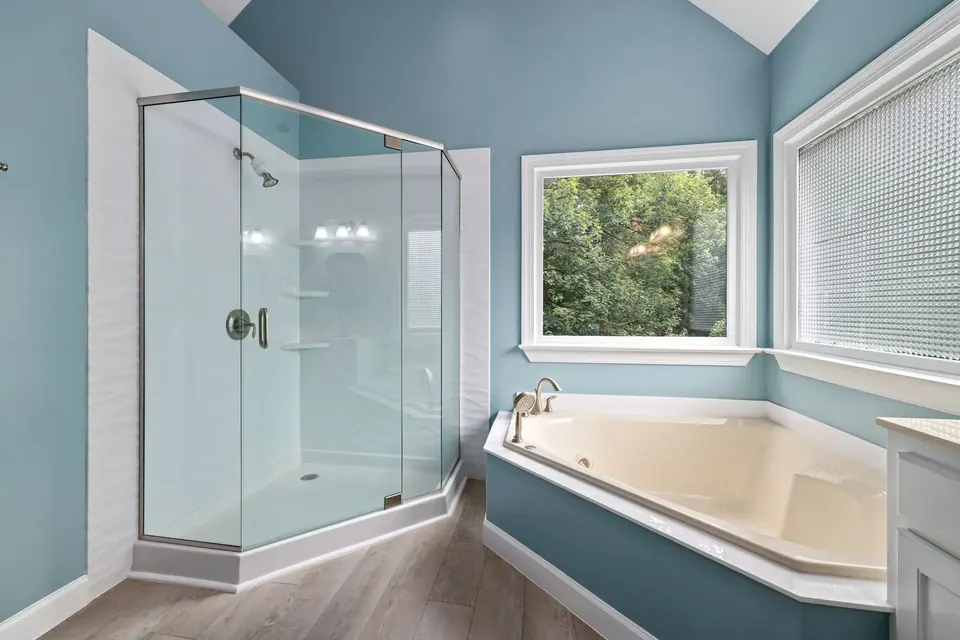 Elegant bathroom featuring a glass shower and bathtub with natural light