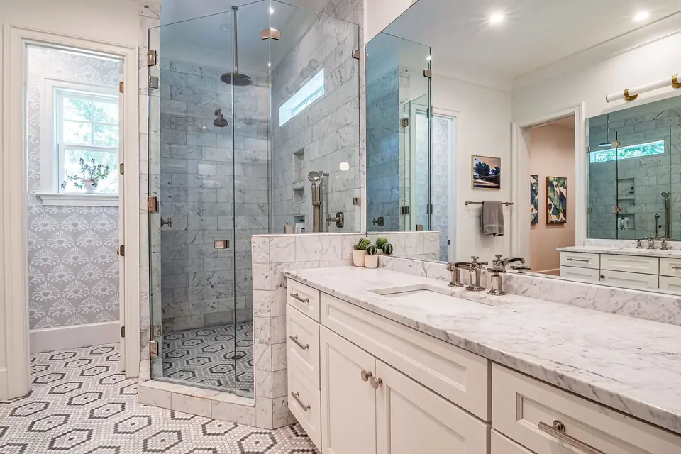 Mediterranean-style bathroom with marble countertops and glass shower