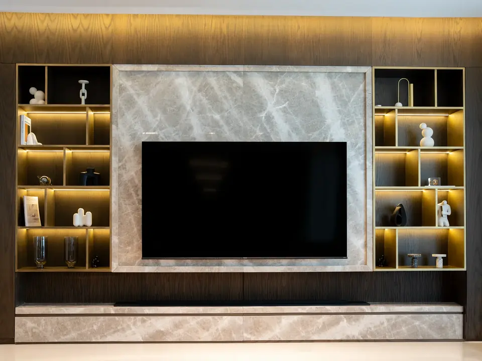 A completed FM Trading interior — marble TV feature wall with backlit display shelving