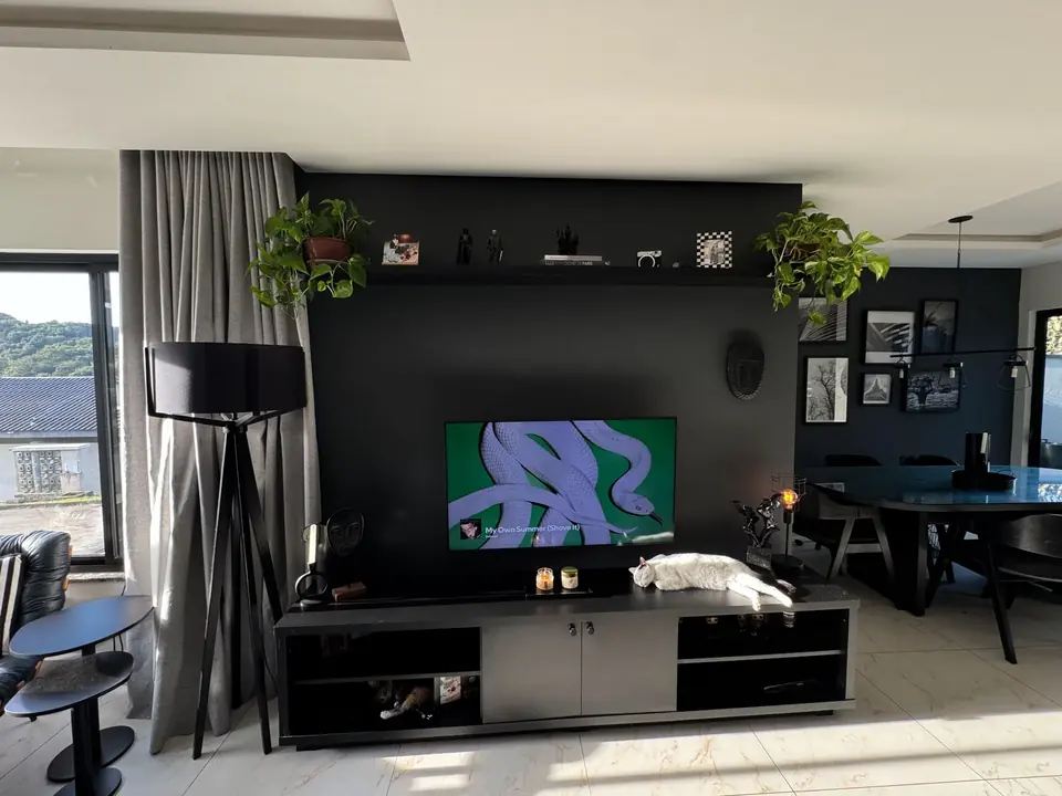 Sleek black wall-mounted TV media unit in a modern living room