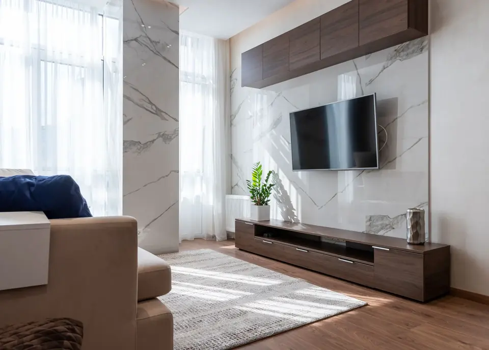 Wall-mounted TV set between wooden panel cabinets in a modern living room
