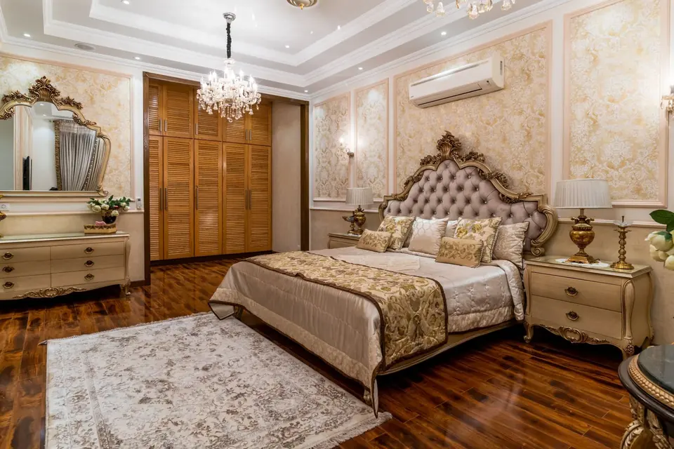 Luxurious bedroom with chandelier, classic furniture, and elegant wallpaper