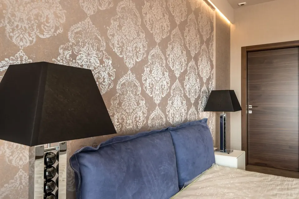 Modern bedroom with elegant wallpaper and blue accent decor