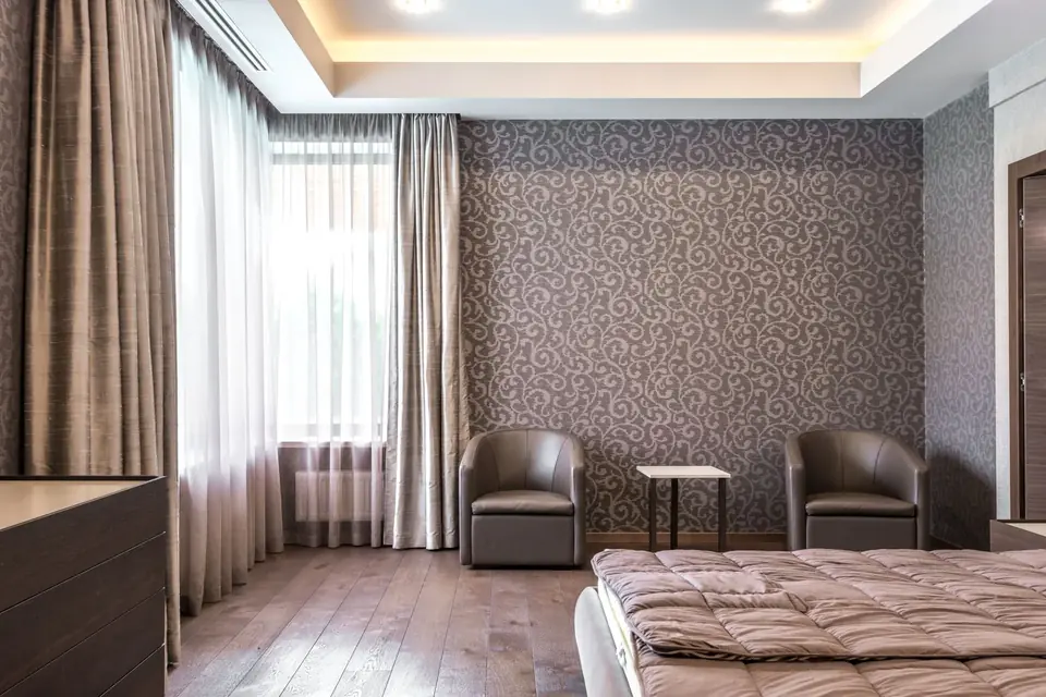 Spacious modern bedroom with stylish wallpaper and elegant furnishings